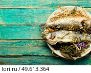 Fish baked in spicy herbs and hay.Roasted sea bass.Copy space. Seabass fish baked with herbs,space for text. Стоковое фото, агентство Ingram Publishing / Фотобанк Лори
