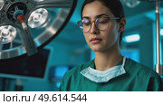 A woman in a green lab coat is wearing gloves and looking at a lighted object. Стоковое AI-видео, аниматор Виктория Кольцова / Фотобанк Лори
