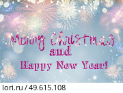 Fireworks colorful explosions on blue, festive background with Merry Christmas greetings. Fireworks explosions on black. Стоковое фото, агентство Ingram Publishing / Фотобанк Лори