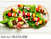 appetizer of shrimps, jamon, fruits and vegetables on wooden skewers.Flat lay. Easy snack from vegetables, fruits, meat and seafood. Стоковое фото, агентство Ingram Publishing / Фотобанк Лори
