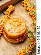 Healthy sea buckthorn jam. Homemade berry jam on an old wooden table. Autumn sea buckthorn jam. Стоковое фото, агентство Ingram Publishing / Фотобанк Лори