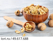 Purified walnuts in a brown wooden bowl on a wooden background. . Стоковое фото, агентство Ingram Publishing / Фотобанк Лори