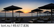 Panoramic photograph of umbrellas and sunloungers on beach in Coral Bay,Cyprus at sunset. Стоковое фото, агентство Ingram Publishing / Фотобанк Лори