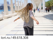 Black female moving her coloured braids in the wind. Typical African hairstyle.. Young black female moving her coloured braids in the wind. Typical African hairstyle. Стоковое фото, агентство Ingram Publishing / Фотобанк Лори