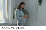 Brunette woman dance, have fun at home listens song, moves to music, feels overjoyed, celebrate good news, relish carefree life looks happy. Young adult female twirls, grooves. Lady dancing in kitchen. Стоковое видео, видеограф Марина Демидюк / Фотобанк Лори