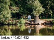 guy and a girl walk along the paths of a forest park between tall trees. Стоковое фото, агентство Ingram Publishing / Фотобанк Лори