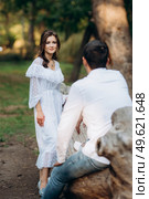 guy and a girl walk along the paths of a forest park between tall trees. Стоковое фото, агентство Ingram Publishing / Фотобанк Лори
