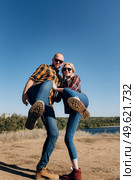 Guy and girl in caged shirts and trekking shoes on granite rocks. Стоковое фото, агентство Ingram Publishing / Фотобанк Лори