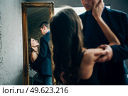 the girl reaches out to the guy and their images are reflected in the floor mirror. Стоковое фото, агентство Ingram Publishing / Фотобанк Лори