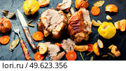 Pork knuckle or shank stewed in dark beer with quince and apples.. Roasted meat with autumn fruits. Стоковое фото, агентство Ingram Publishing / Фотобанк Лори