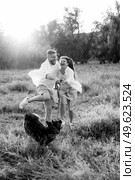 Big dog for a walk with a guy and a girl on the green prairie. Стоковое фото, агентство Ingram Publishing / Фотобанк Лори