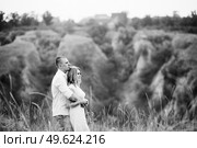 a guy with a girl in light clothes on the background of a green canyon of erosion of the earth. Стоковое фото, агентство Ingram Publishing / Фотобанк Лори