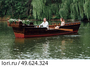 a boat trip for a guy and a girl along the canals and bays of the river overgrown with wild willows. Стоковое фото, агентство Ingram Publishing / Фотобанк Лори