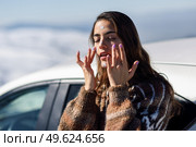 Young woman applying sunscreen on her face in snowy mountains in winter, in Sierra Nevada, Granada, Spain. Female wearing winter clothes.. Young woman applying sunscreen on her face in snow landscape. Стоковое фото, агентство Ingram Publishing / Фотобанк Лори