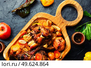 Pork knuckle or shank grilled with apples on cutting board. Roasted meat with autumn fruits. Стоковое фото, агентство Ingram Publishing / Фотобанк Лори