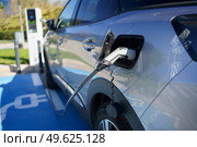 Car charging its electric battery at one charging point for electric vehicles located on the street.. Refueling an electric car, an environment friendly alternative. Стоковое фото, агентство Ingram Publishing / Фотобанк Лори