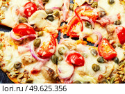 Pizza with salami, cheese, tomato on a pumpkin crust. Homemade autumn recipe. Pizza on pumpkin flatbread. Стоковое фото, агентство Ingram Publishing / Фотобанк Лори