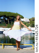 African girl walking along a seaport wearing a nice summer dress.. African woman walking along a seaport wearing a nice summer dress. Стоковое фото, агентство Ingram Publishing / Фотобанк Лори