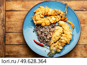 Fried sea bass fish with rice on rice paper. Roasted seafood. Appetizing grilled sea bass fish. Стоковое фото, агентство Ingram Publishing / Фотобанк Лори