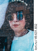Sad woman alone in her home looking through a window in a rainy day. Стоковое фото, агентство Ingram Publishing / Фотобанк Лори