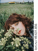 Young beautiful woman resting in a field of flowers. Стоковое фото, агентство Ingram Publishing / Фотобанк Лори