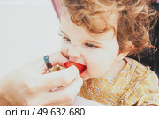 Little baby girl eating a strawberry. Стоковое фото, агентство Ingram Publishing / Фотобанк Лори