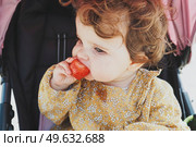 Little baby girl eating a strawberry. Стоковое фото, агентство Ingram Publishing / Фотобанк Лори