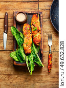 Tasty chicken breast skewers and peanut sauce. Chicken satay on kitchen board. Chicken shashlik with peanut sauce. Стоковое фото, агентство Ingram Publishing / Фотобанк Лори