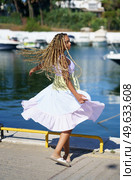 Young mixed woman walking along a seaport wearing a nice summer dress.. Mixed woman walking along a seaport wearing a nice summer dress. Стоковое фото, агентство Ingram Publishing / Фотобанк Лори