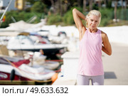 Mature sportswoman stretching her triceps after exercise. Concept of healthy living in the elderly. Senior woman in fitness clothing. Older female doing sport to keep fit.. Mature sportswoman stretching her triceps after exercise. Стоковое фото, агентство Ingram Publishing / Фотобанк Лори