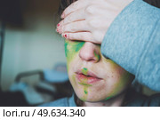 Moody portrait of a young woman with her face painted of green. Стоковое фото, агентство Ingram Publishing / Фотобанк Лори