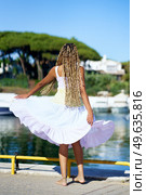 African girl walking along a seaport wearing a nice summer dress.. African woman walking along a seaport wearing a nice summer dress. Стоковое фото, агентство Ingram Publishing / Фотобанк Лори