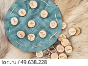 Handmade runes for fortunetelling over green leather chart. Handmade runes for fortunetelling. Стоковое фото, агентство Ingram Publishing / Фотобанк Лори