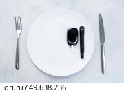 Diabetes diet planning concept, empty plate with fork, knife and glukemetr, fasting diet and dieabetes sugar level control equipment. Diabetes diet planning concept. Стоковое фото, агентство Ingram Publishing / Фотобанк Лори