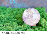 Crystal ball of aametist stone on mysterious natural forest background. Magic healing Rock for Crystal Ritual, Witchcraft, spiritual esoteric practice. Healing crystals on brown background. Стоковое фото, агентство Ingram Publishing / Фотобанк Лори