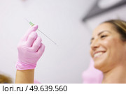 Doctor showing a PDO treatment suture thread to her patient. Middle-aged woman.. Doctor showing a PDO treatment suture thread to her patient. Стоковое фото, агентство Ingram Publishing / Фотобанк Лори