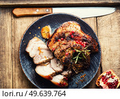 Tasty fried pork belly with spices and herbs. Fatty piece of meat on old table. Baked pork belly, meatloaf. Стоковое фото, агентство Ingram Publishing / Фотобанк Лори
