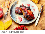 Prepared pork steak with berry sauce on retro wooden table. Fried pork with viburnum,meat dish. Стоковое фото, агентство Ingram Publishing / Фотобанк Лори