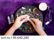 Top view of astrologer hands making forecast of fate. Astrological forecast, mysticismm and science concept. Astrological background.. Top view of astrologer hands. Стоковое фото, агентство Ingram Publishing / Фотобанк Лори