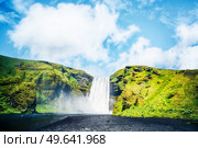 Waterfall between green cliffs under a blue sky in Iceland. Стоковое фото, агентство Ingram Publishing / Фотобанк Лори