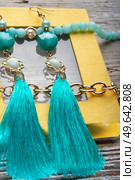beautiful handmade  turquoise  jewelry with natural gems in yellow box around old style wooden background. macro shot. fashion concept. Стоковое фото, агентство Ingram Publishing / Фотобанк Лори