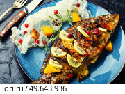 Baked fish carp with fruits, berries and spices.. Tasty crucian fried with kiwi and mango. Стоковое фото, агентство Ingram Publishing / Фотобанк Лори