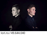 Positive vs negative energy, split personality metaphor. Twins with different emotions standing back to back, pessimist against optimist. Bipolar disorder concept. Стоковое фото, агентство Ingram Publishing / Фотобанк Лори