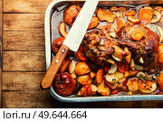 Pork knuckle or shank stewed in dark beer with quince and apples.Autumn meat recipe. Baked meat with autumn fruits. Стоковое фото, агентство Ingram Publishing / Фотобанк Лори