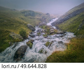 Fast stream flowing across a rocky valley in Fagaras Mountains. River with waterfalls and dense mist landscape. Стоковое фото, агентство Ingram Publishing / Фотобанк Лори