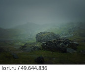 Big mountain rocks and boulders seen through the dense mist. Moody hiking scene with rainy weather. Стоковое фото, агентство Ingram Publishing / Фотобанк Лори