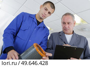 apprentice and mentor replacing of motor filter at garage. Стоковое фото, агентство Ingram Publishing / Фотобанк Лори