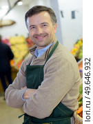 portrait of a handsome seller with arms crossed in supermarket. Стоковое фото, агентство Ingram Publishing / Фотобанк Лори
