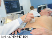doctor using ultrasound scan on abdomen of senior male patient. Стоковое фото, агентство Ingram Publishing / Фотобанк Лори