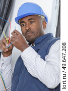 electrician looking at socket cables. Стоковое фото, агентство Ingram Publishing / Фотобанк Лори